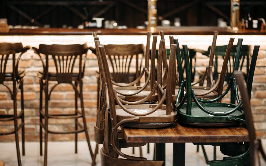 Image of a closed restaurant with chairs stacked on tables.